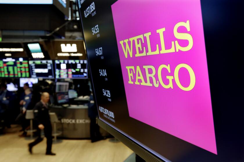 FILE - This May 17, 2018 file photo shows the Wells Fargo logo above a trading post on the floor of the New York Stock Exchange. Wells Fargo is selling more than 50 retail bank branches in Indiana, Michigan, Wisconsin and Ohio to a Flagstar Bancorp subsidiary. (AP Photo/Richard Drew, File)