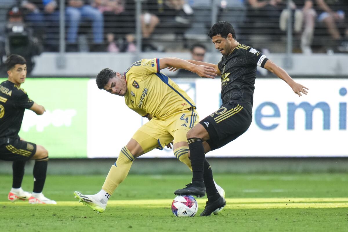 LAFC forward Carlos Vela controls the ball under pressure from Real Salt Lake defender Brayan Vera.