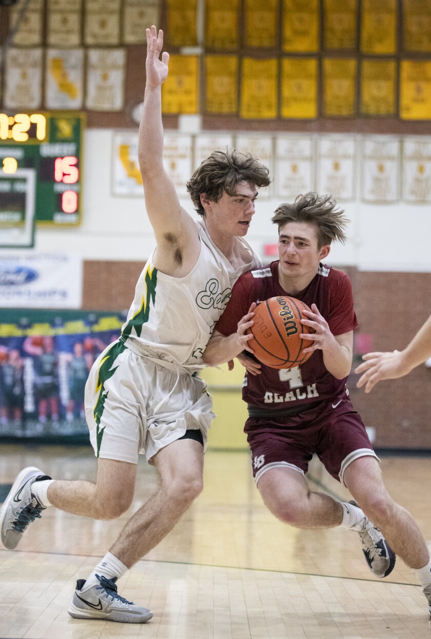 Laguna Beach's Kai Gillies drives against Edison's Quinn Delaney during a Surf League boys' basketball game on Wednesday.