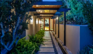  La maison à flanc de colline comprend trois niveaux de terrasses, balcons et patios, ainsi qu'une piscine et un spa.