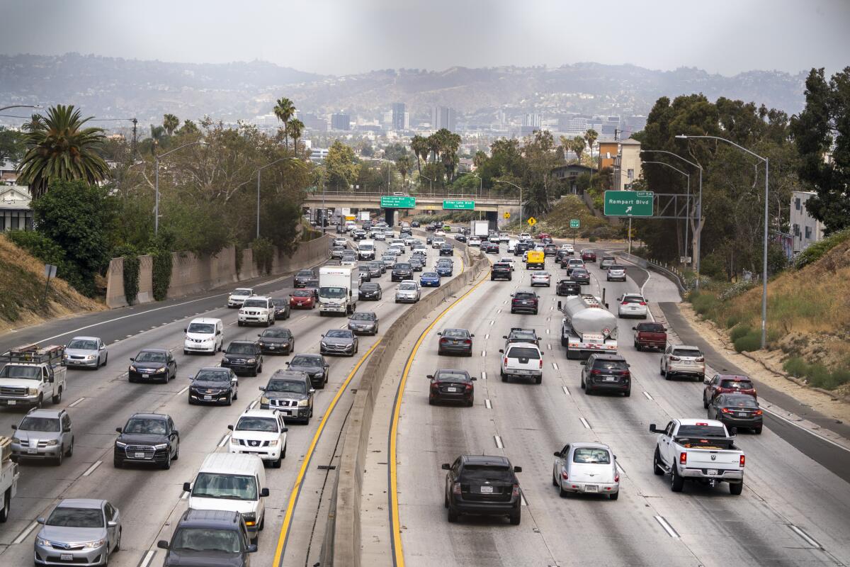 Cars on the freeway with a view of the skyline.