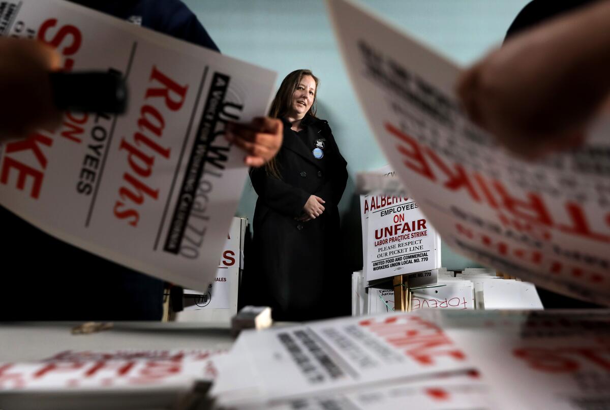 A woman poses amid union strike signage.