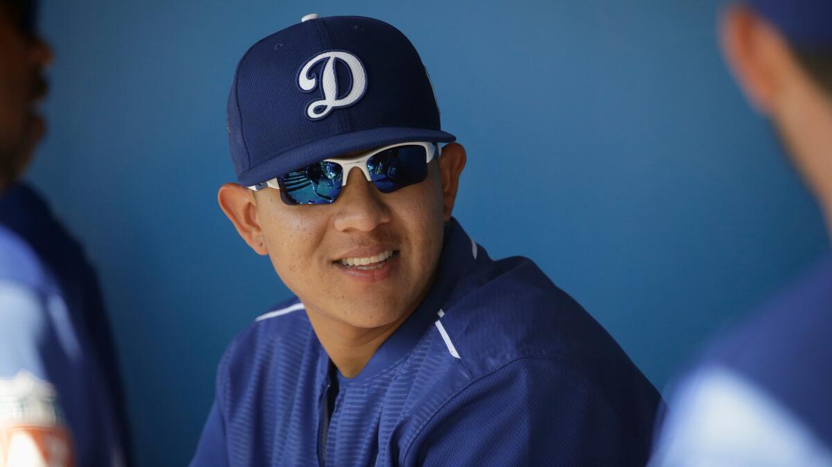 Pitcher Julio Urias talks to teammates in the Dodgers dugout during spring training.