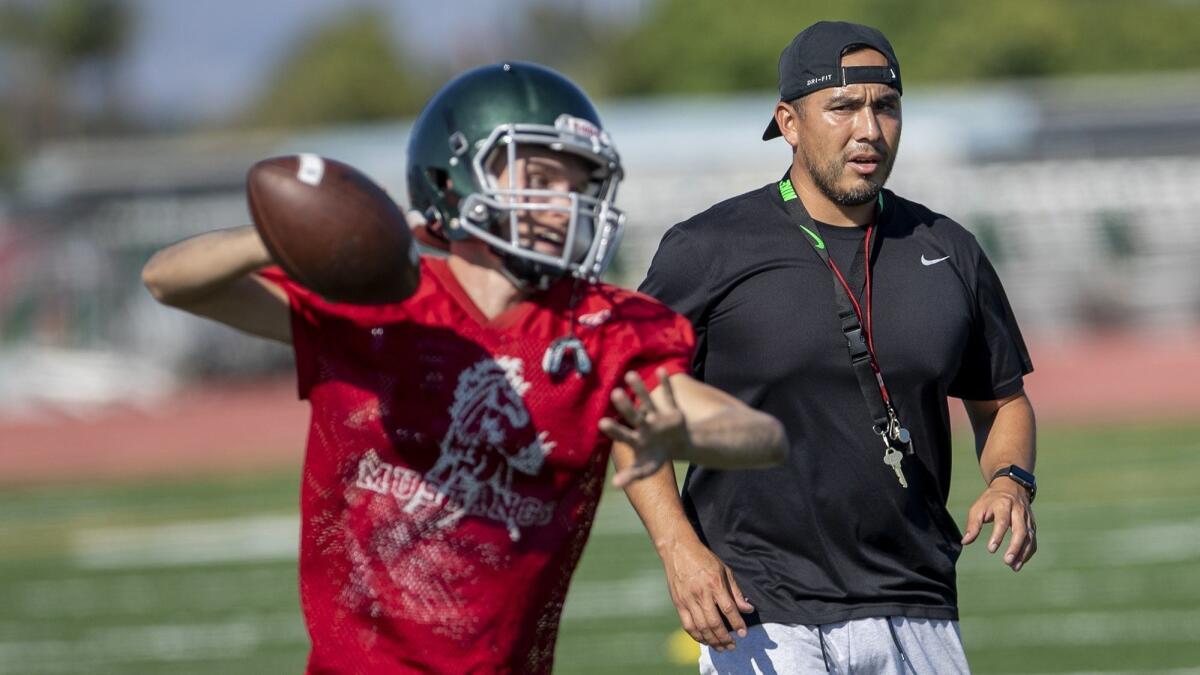 Costa Mesa High coach David Gutierrez, pictured on the right during a practice on Aug. 14, will face his former team in Santa Ana on Thursday.