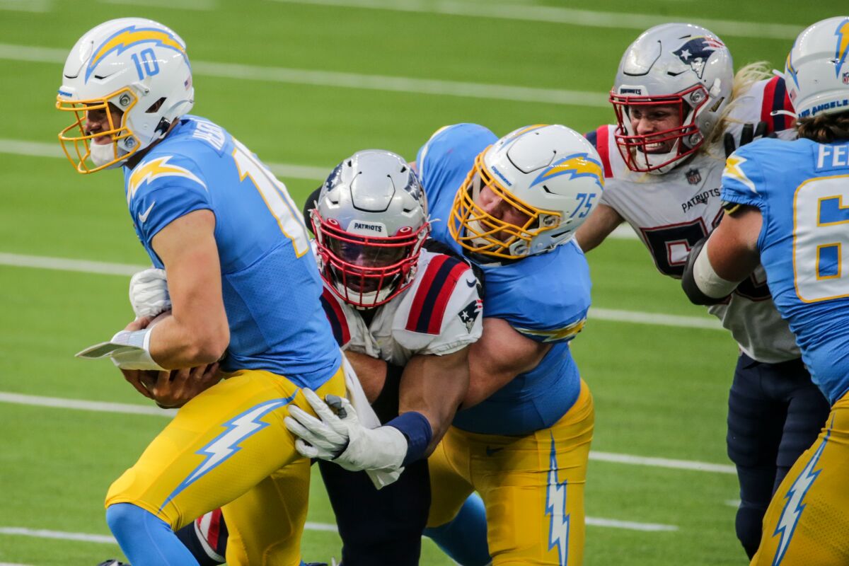 Chargers quarterback Justin Herbert tries to escape a tackle during Sunday's game.