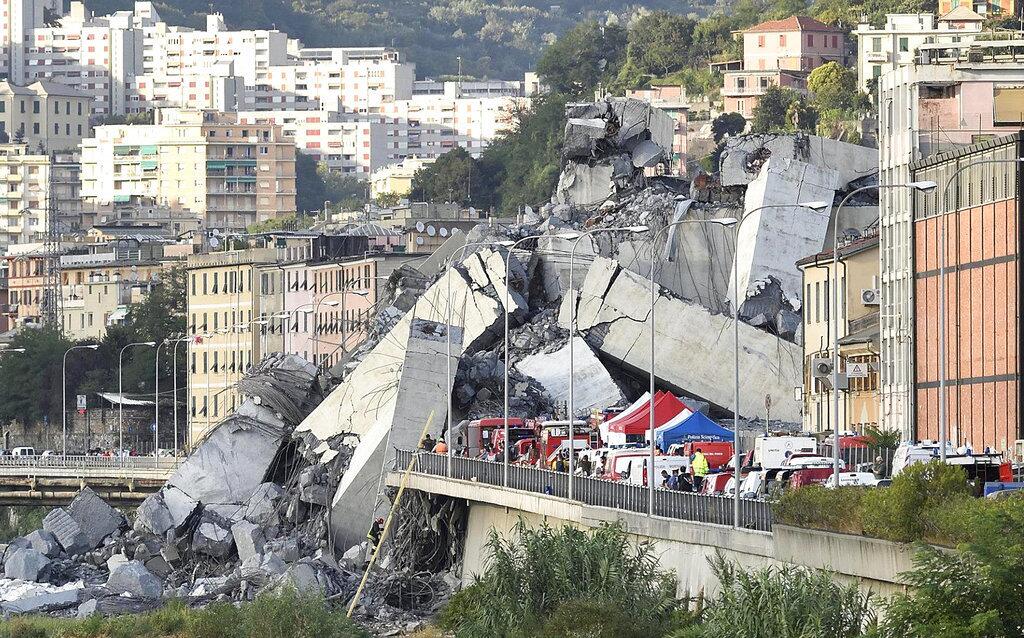 Rescuers work to recover an injured person after the Morandi highway bridge collapsed in Genoa, northern Italy, Tuesday, Aug. 14, 2018. The highway bridge collapsed during a violent storm, sending vehicles plunging 45 meters (nearly 150 feet) into a heap of rubble. Authorities said at least 20 people were killed, although some people were found alive in the debris. (Luca Zennaro/ANSA via AP)