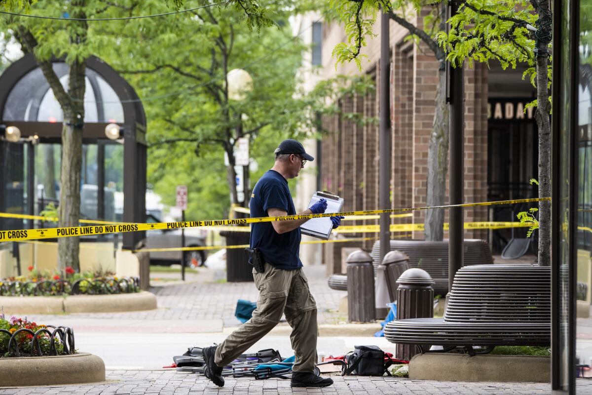 Members of the FBI's Evidence Response Team Unit investigate on Central Avenue near Green Bay Road in downtown Highland Park