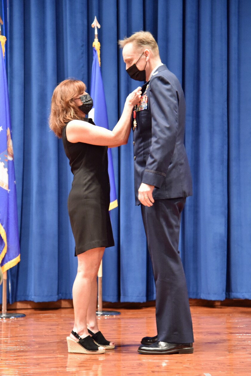 Johnson's wife, Jill Koshak-Johnson, puts on Brad’s retirement pin at the ceremony on Nov. 10, 2021.
