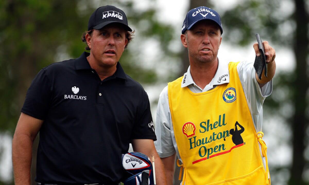 Phil Mickelson, left, speaks with his caddy, Jim Mackay, during the first round of the Houston Open on Thursday.