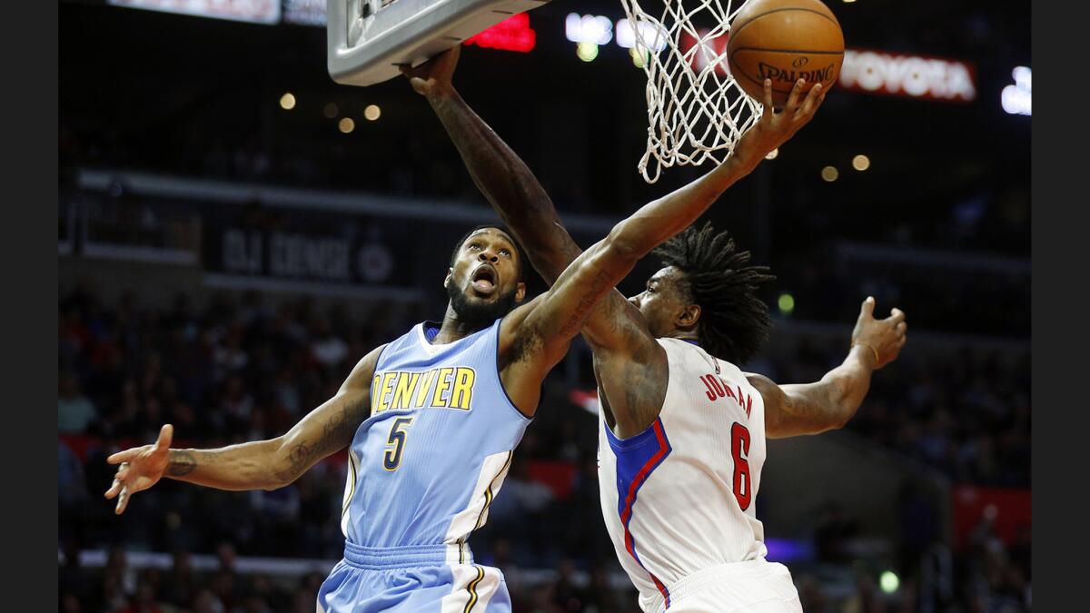 Clippers center DeAndre Jordan (6) guards Denver Nuggets guard Will Barton (5) during the Clippers' 119-102 win at the Staples Center on Tuesday.