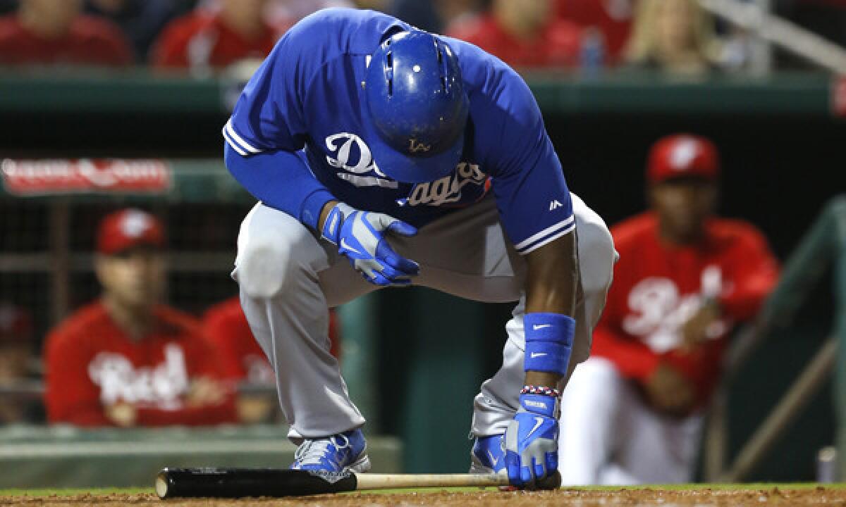 Dodgers right fielder Yasiel Puig goes to pick up his bat during the fourth inning of Wednesday's exhibition game against the Cincinnati Reds. Puig left the game after two at-bats because inflammation in his back.