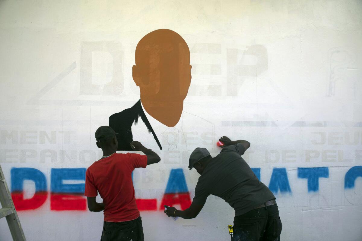 Artists paint a portrait of slain Haitian President Jovenel Moise near the presidencial residence where he was assassinated in the Petion-ville area of Port-au-Prince, Haiti, Thursday, July 7, 2022. A year has passed since Moise was assassinated at his private home. (AP Photo/Odelyn Joseph)