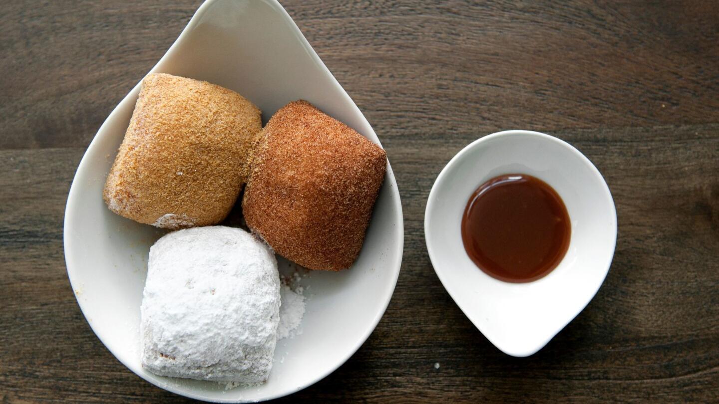 A trio of sweet beignets (graham cracker, cinnamon and powder sugar) with salted caramel dipping sauce at Beverly Hills Beignets on Tuesday.