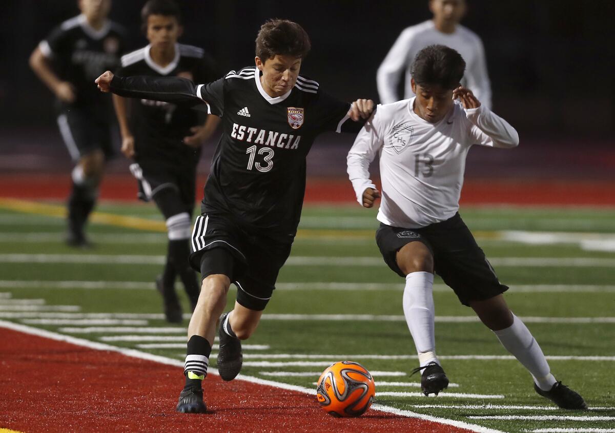 Estancia's Jesus Guerrero, left, and Century's Jason Rodriguez compete for a loose ball during the first half of a nonleague match on Wednesday at Jim Scott Stadium in Costa Mesa.