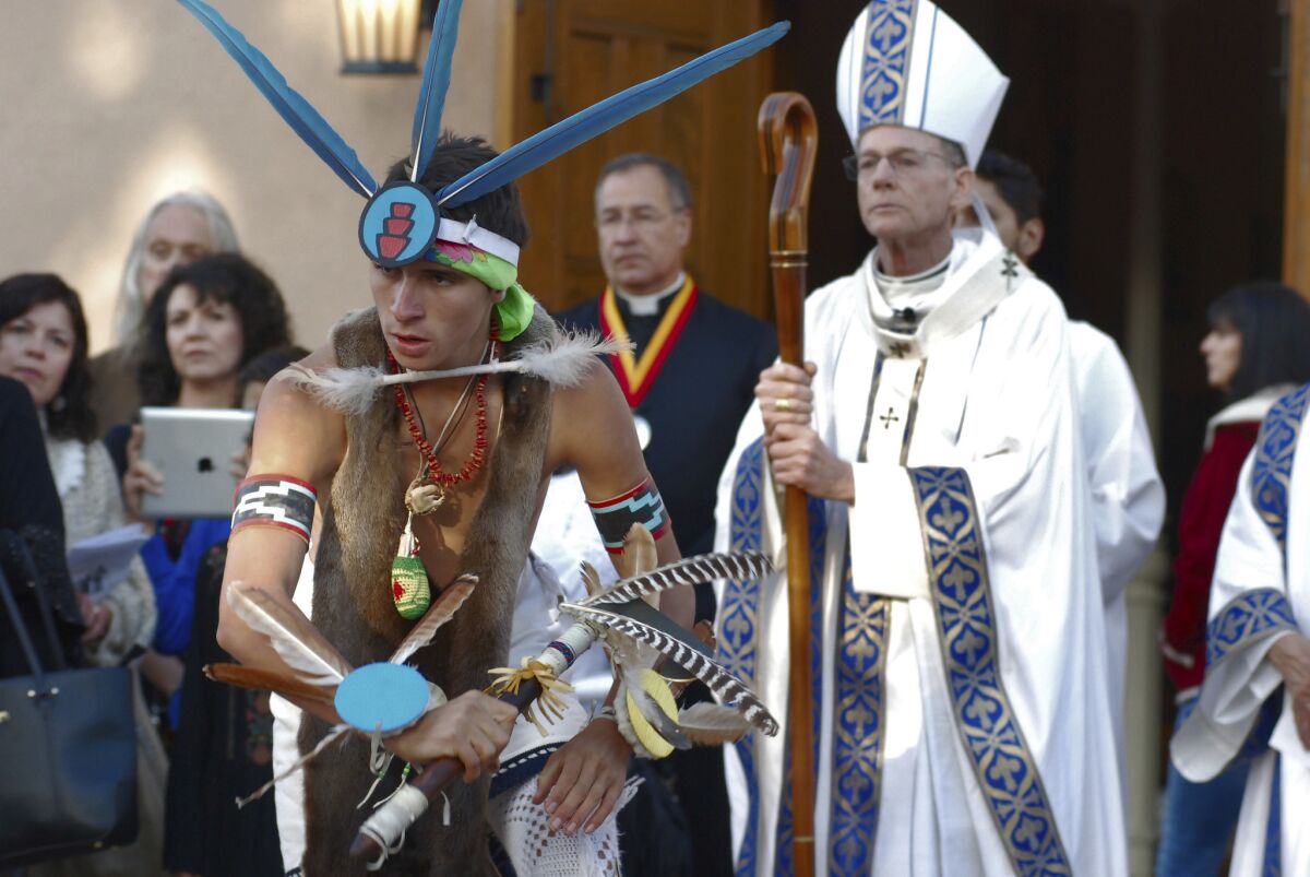 Dezmund Marcus of Ohkay Owingeh, N.M., performs the butterfly dance at the outset of an annual autumn festival in front of a crowd, including Roman Catholic Archbishop John Wester, right, on Friday, in Santa Fe, N.M.