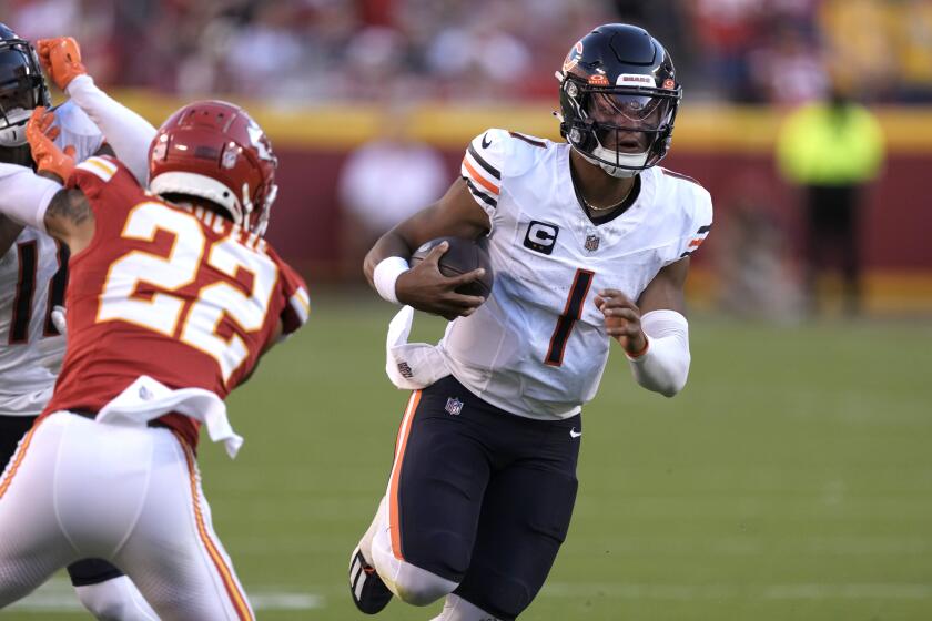 Chicago Bears quarterback Justin Fields (1) runs with the ball as Kansas City Chiefs cornerback Trent McDuffie (22) defends during the second half of an NFL football game Sunday, Sept. 24, 2023, in Kansas City, Mo. (AP Photo/Charlie Riedel)
