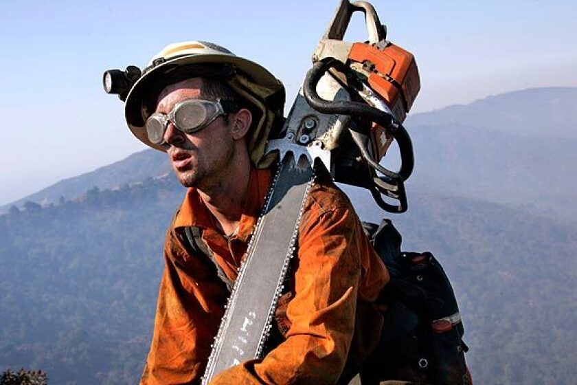 Jonathan Powers climbs back up Newman Point after cutting fire line in the area along Glendora Mountain Road, southeast of Highway 39.