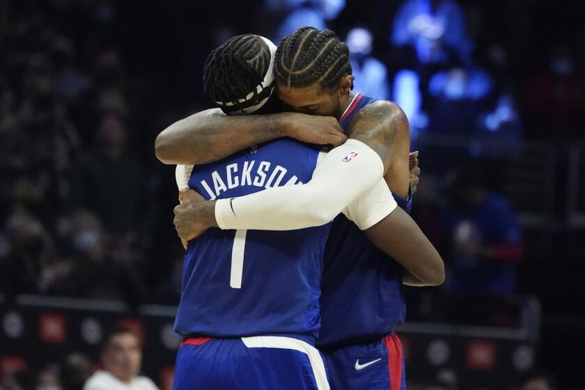 Clippers guard Reggie Jackson (1) gets a hug from close friend and teammate Paul George 