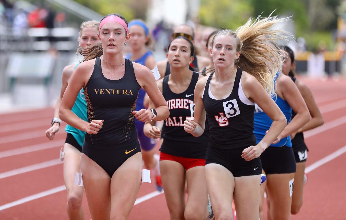 Sadie Engelhardt, left, leads the pack in the 1600 meters on a red track