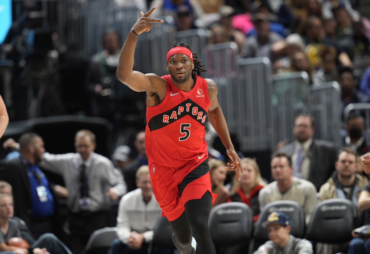 Toronto Raptors forward Precious Achiuwa gestures to the bench after hitting a basket against the Denver Nuggets in the second half of an NBA basketball game Saturday, March 12, 2022, in Denver. (AP Photo/David Zalubowski)