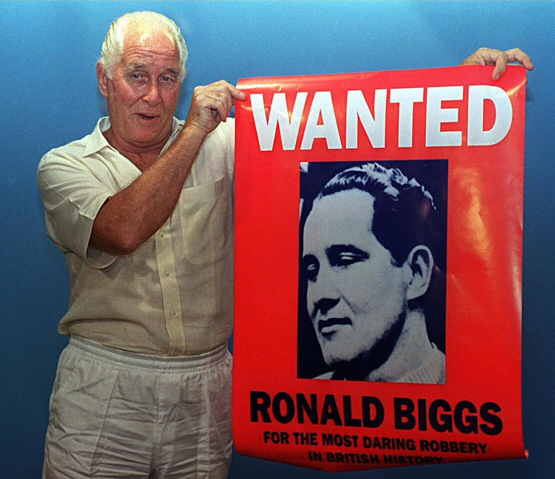 Ronnie Biggs, a fugitive for his participation in Britain's Great Train Robbery of 1963, holds up a poster of himself during promotions for his book "Odd Man Out."