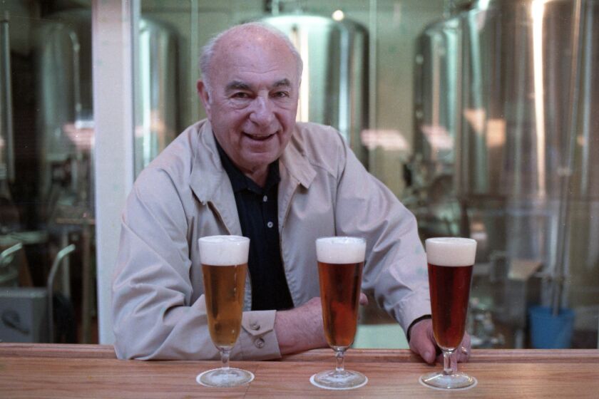 Karl Strauss, the German-born master brewer behind the bar with some of his creations at San Diego's first pub brewery, Karl Strauss' Old Columbia Brewery & Grill at 1157 Columbia St. in San Diego, California, on Feb. 1, 1989. The fermentation room is in the background. Tribune photo by Howard Lipin