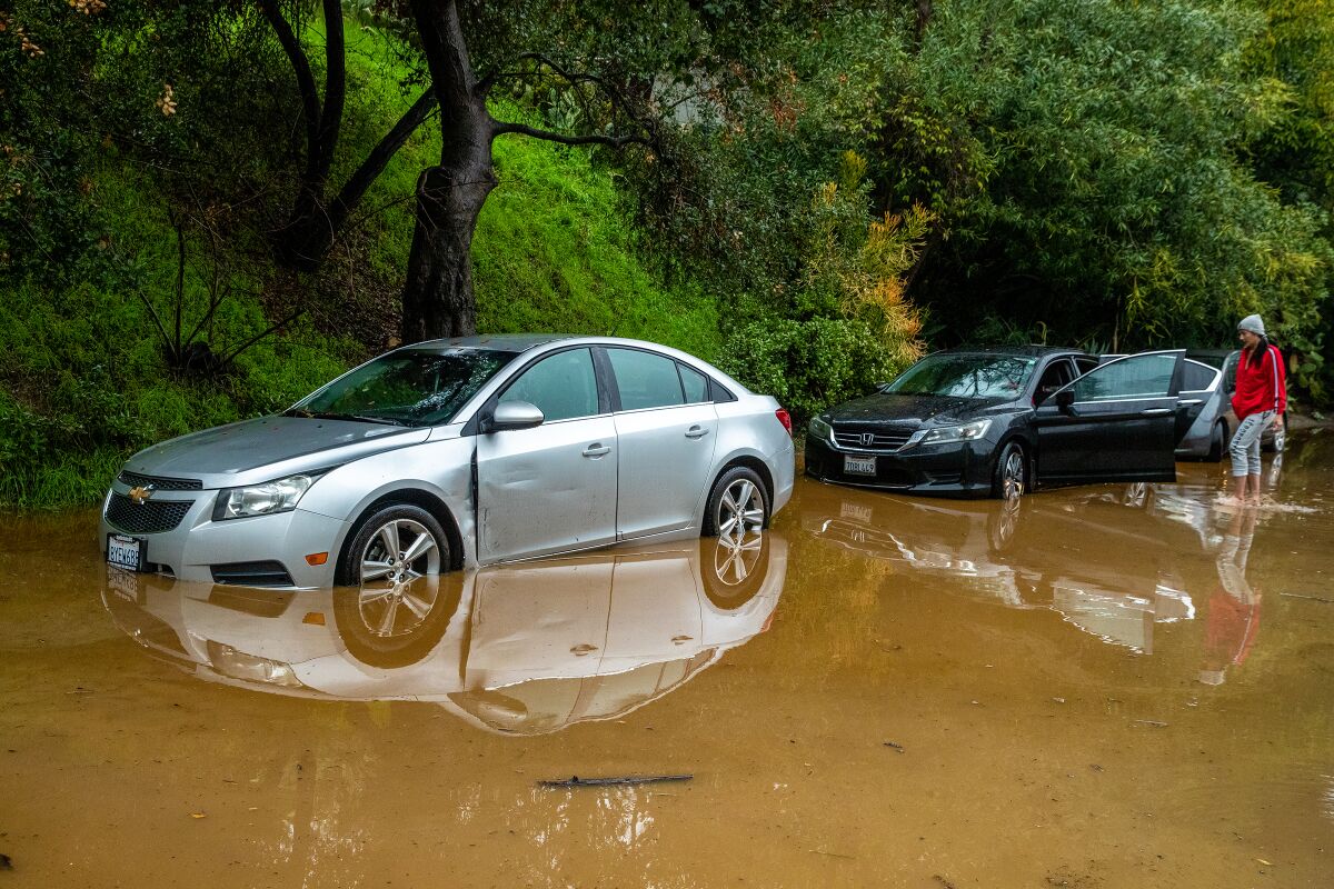 Cars are parked on a flooded hillside street at the 3700 block of North Fredonia Drive