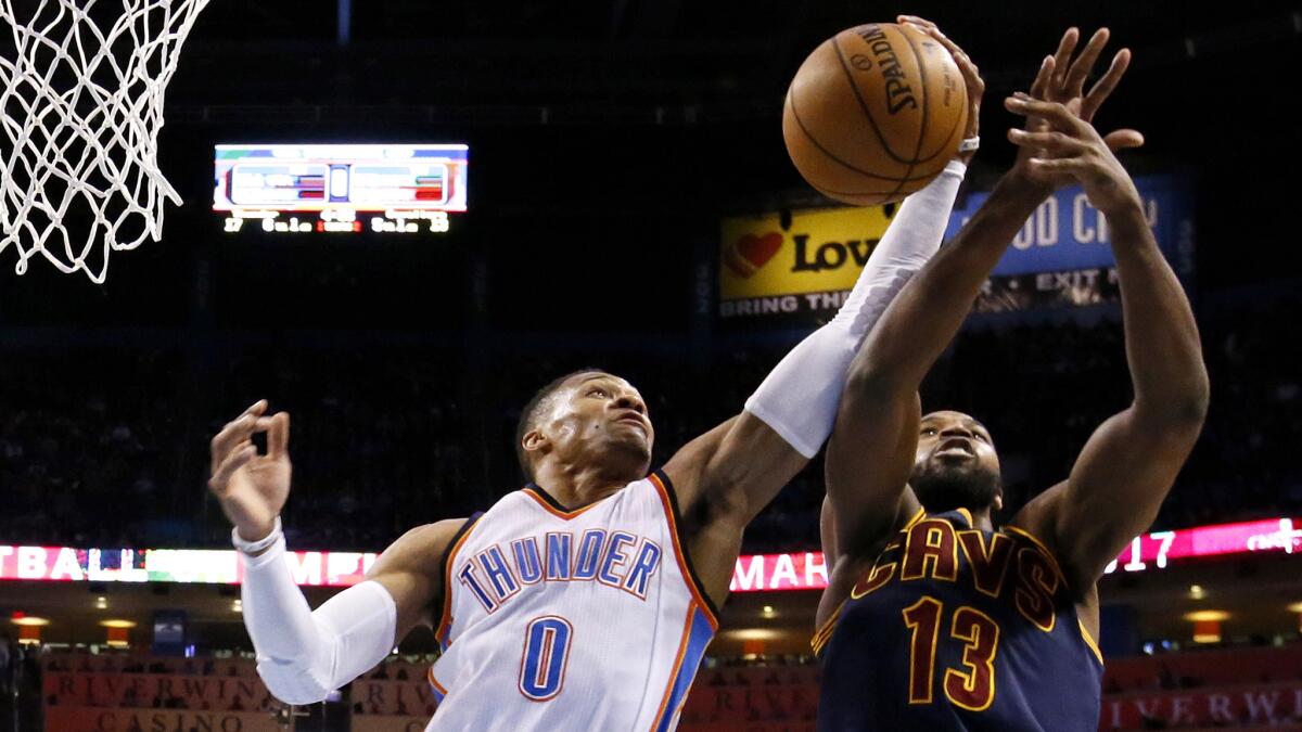 Thunder guard Russell Westbrook (0) grabs a rebound in front of Cavaliers center Tristan Thompson (13) during the first quarter Thursday night.