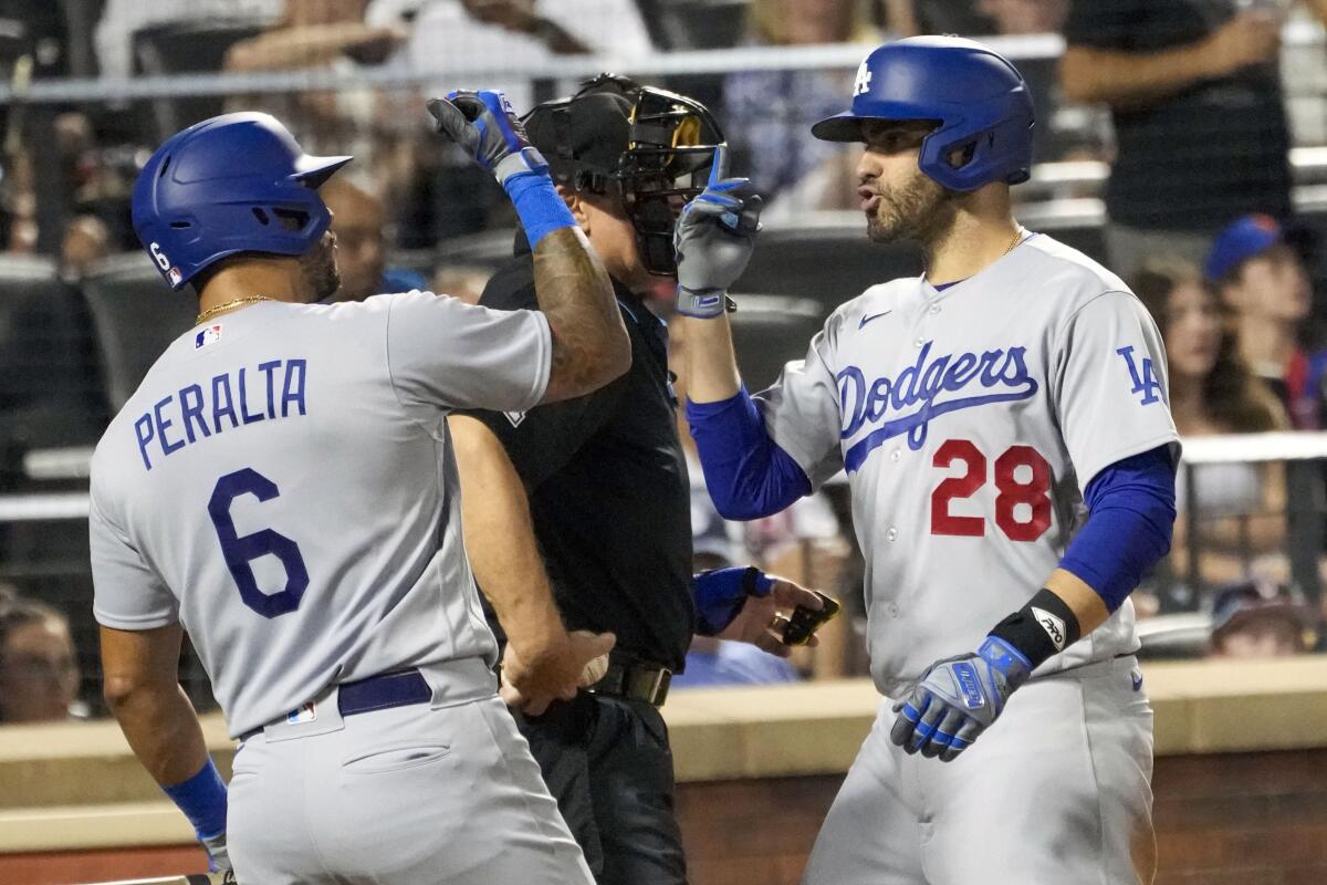 Dodgers' J.D. Martinez celebrates with teammate David Peralta after hitting a solo home run.