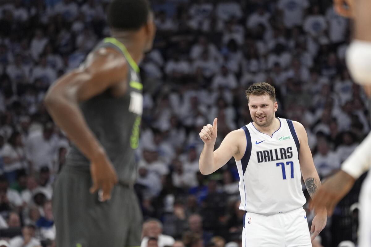 Dallas guard Luka Doncic, right, celebrates during the first half of the Mavericks' win over Minnesota.