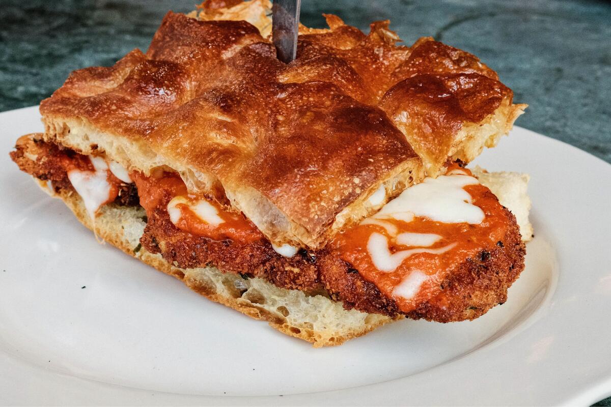 A vodka-sauce chicken parm sandwich on fresh focaccia, knife through the top