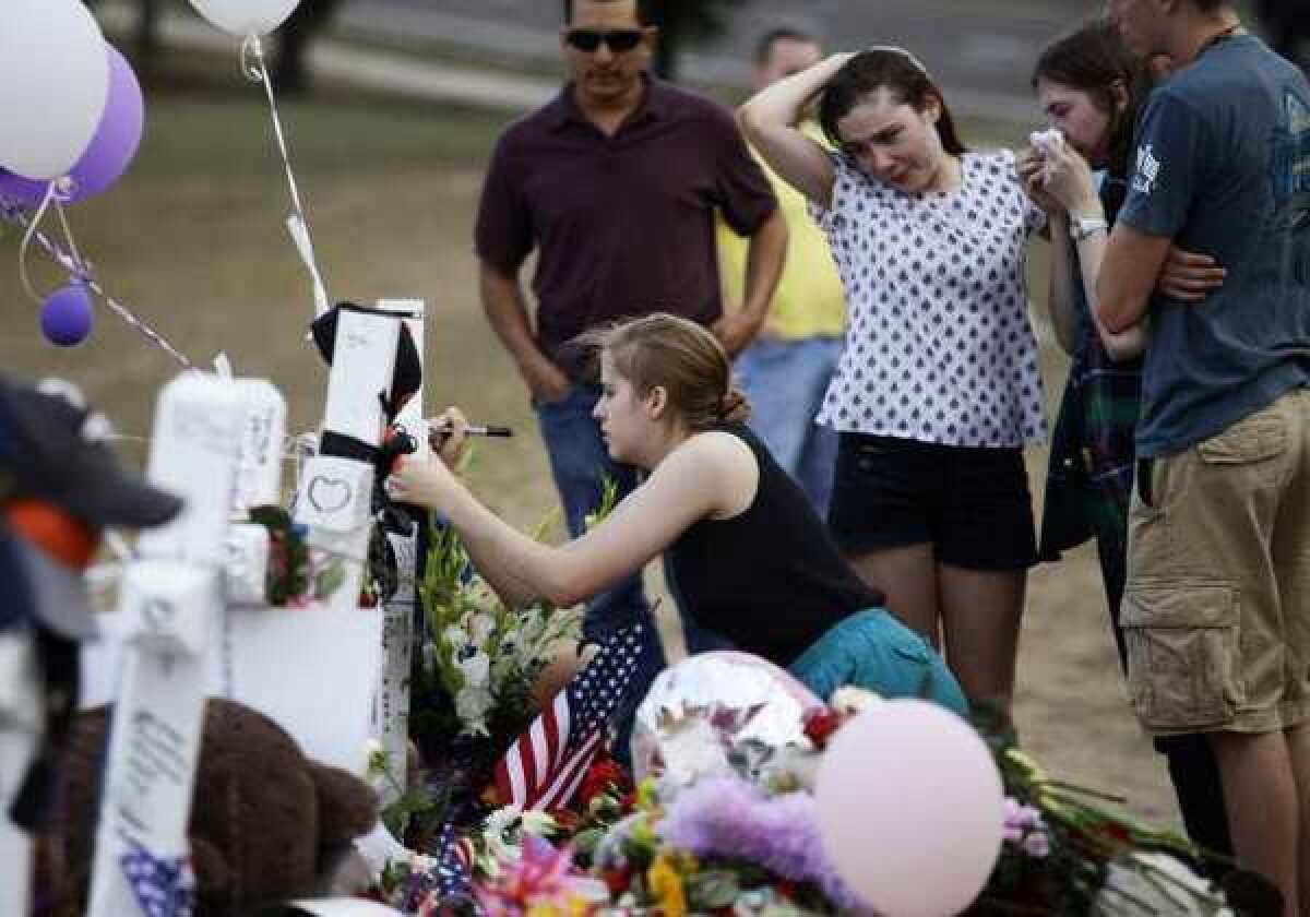Mourners gather at a makeshift memorial across the street from the Century 16 movie theater in Aurora, Colo. The memorial was created for those killed during a mass shooting at the theater July 20, 2012.