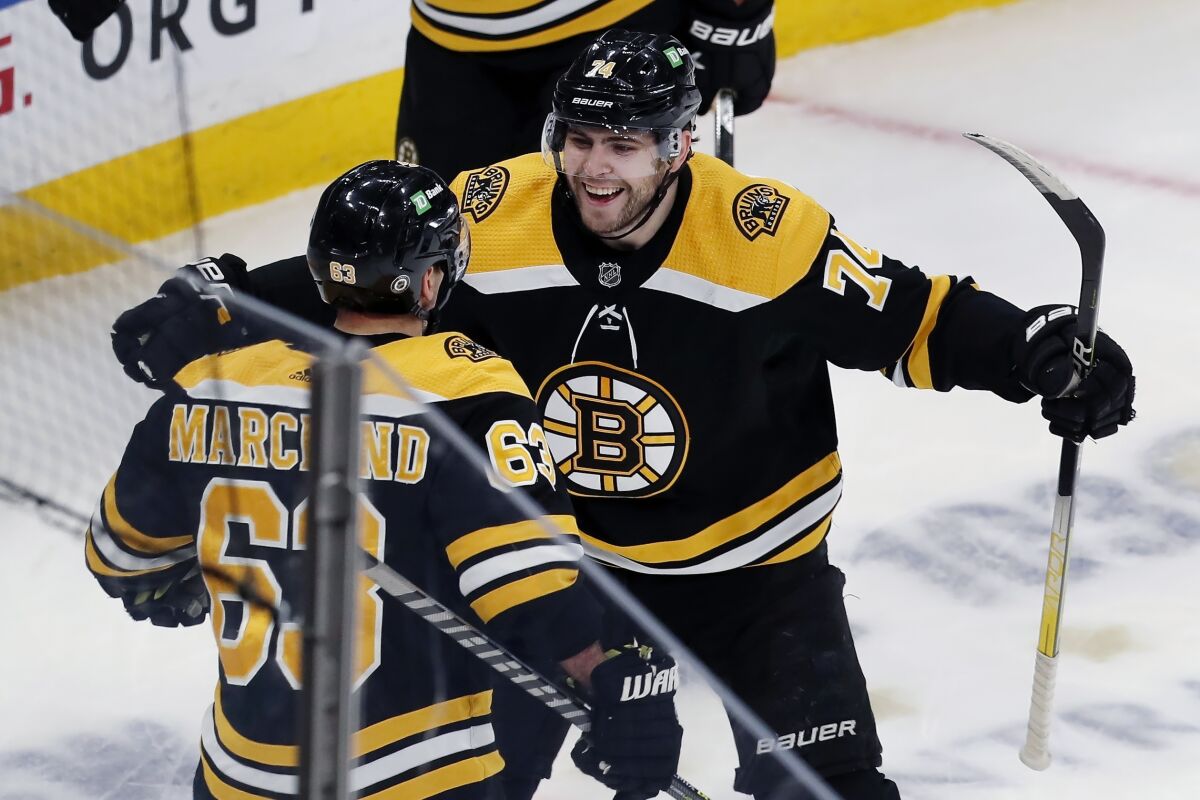 Boston Bruins' Brad Marchand (63) celebrates his goal with teammate Jake DeBrusk (74) during the second period of an NHL hockey game against the Columbus Blue Jackets, Saturday, April 2, 2022, in Boston. (AP Photo/Michael Dwyer)