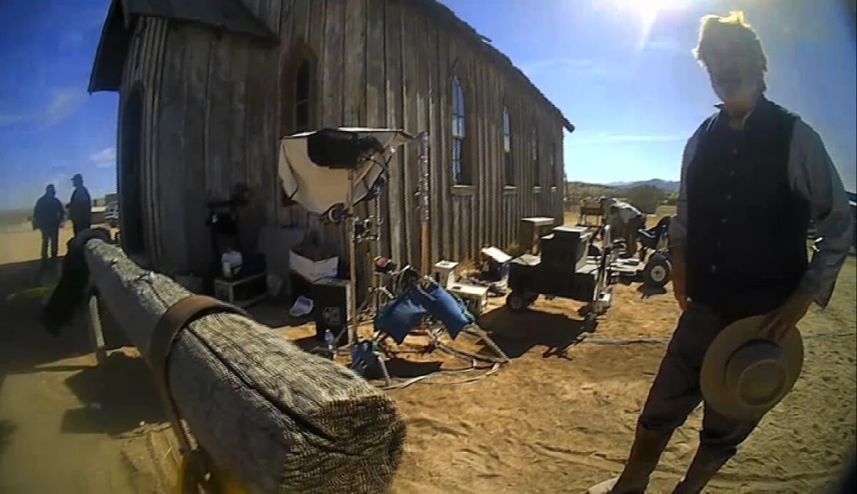 A still from video of a man on a western movie set looking at the camera