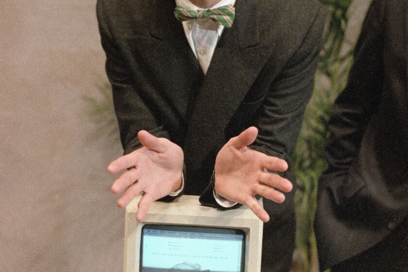 File - Steven Jobs, then chairman of the board of Apple Computer, leans on the new Macintosh personal computer following a shareholder's meeting Jan. 24, 1984 in Cupertino, Ca. The Macintosh computer lived up to the revolutionary promise made by Apple co-founder Jobs at it's 1984 unveiling. (AP Photo/Paul Sakuma, File)