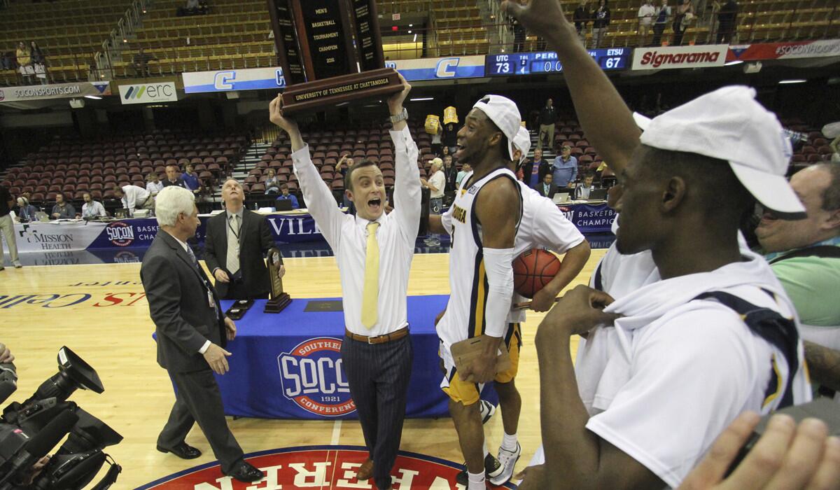 Chattanooga coach Matt McCall celebrates with his team after winning the Southern Conference men's basketball championship against East Tennessee State University in Asheville, N.C.