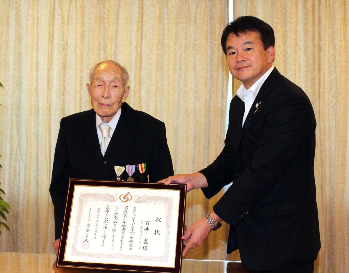 Sakari Momoi, 111, of Saitama, Japan, left, receives a certificate from Mayor Hatato Shimizu on Respect for the Age Day on Sept. 13. Momoi became the world's oldest man with the death this week of Polish-born Alexander Imich in New York.