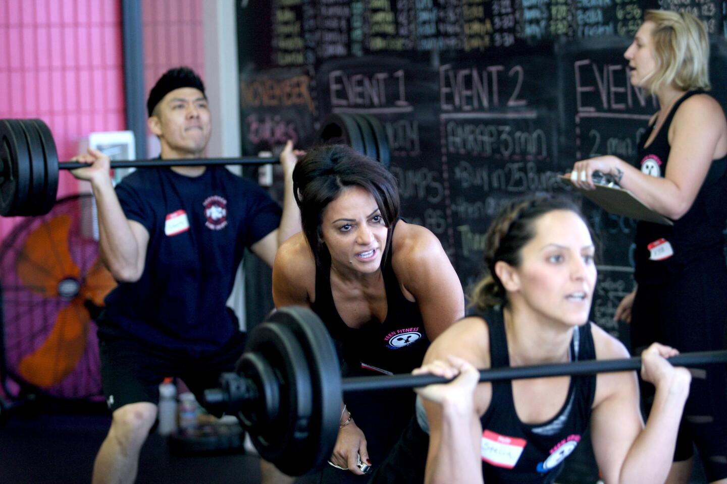 Keen Fitness owner Ankeen Soulat, center, encourages competitor Stella Amirganian, front, during fundraising event with Glendale Fire Dept. personnel to raise funds for Firefighters Quest For Burn Survivors at Keen Fitness in Montrose on Saturday, November 7, 2015.