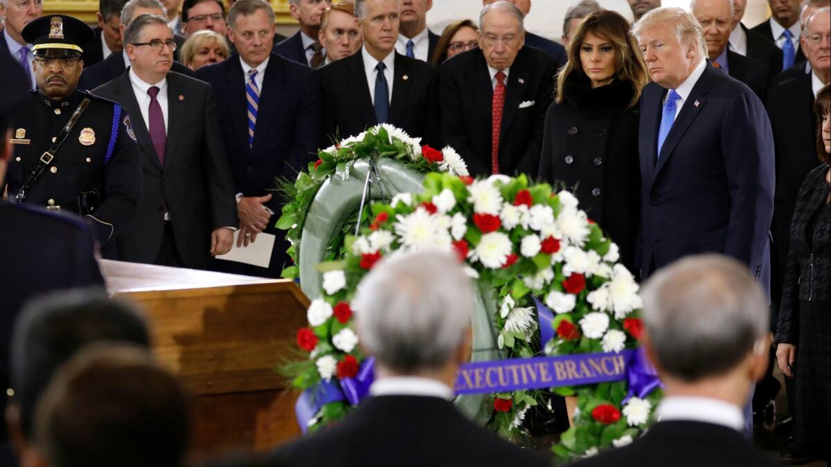 President Trump and First Lady Melania Trump pay their respects Wednesday at the casket of the late evangelist Billy Graham in the Rotunda of the U.S. Capitol.