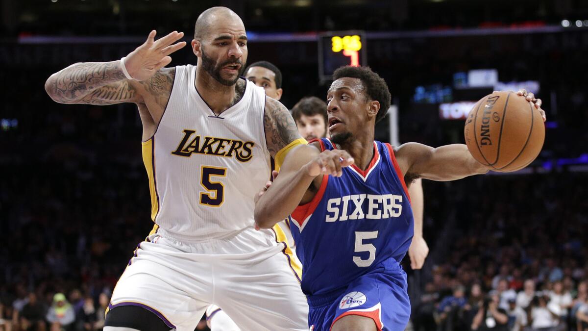 Philadelphia 76ers guard Ish Smith, right, dribbles past Lakers forward Carlos Boozer on March 22.