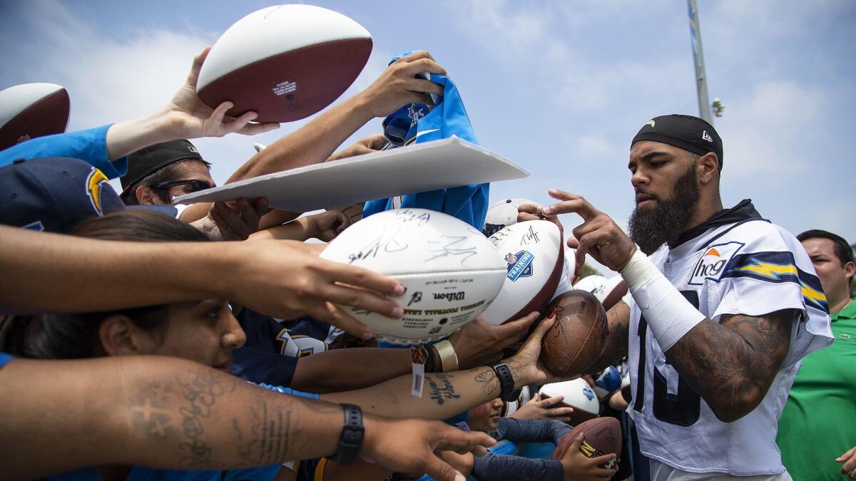 Chargers wide receiver Keenan Allen signs autographs after training camp.
