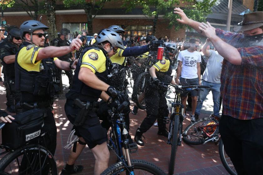 After a confrontation between authorities and protestors, police use pepper spray as multiple groups, including Rose City Antifa, the Proud Boys and others protest in downtown Portland, Ore., on Saturday, June 29, 2019. In separate social media posts later in the day, police declared the situation to be a civil disturbance and warned participants faced arrest. (Dave Killen/The Oregonian via AP)