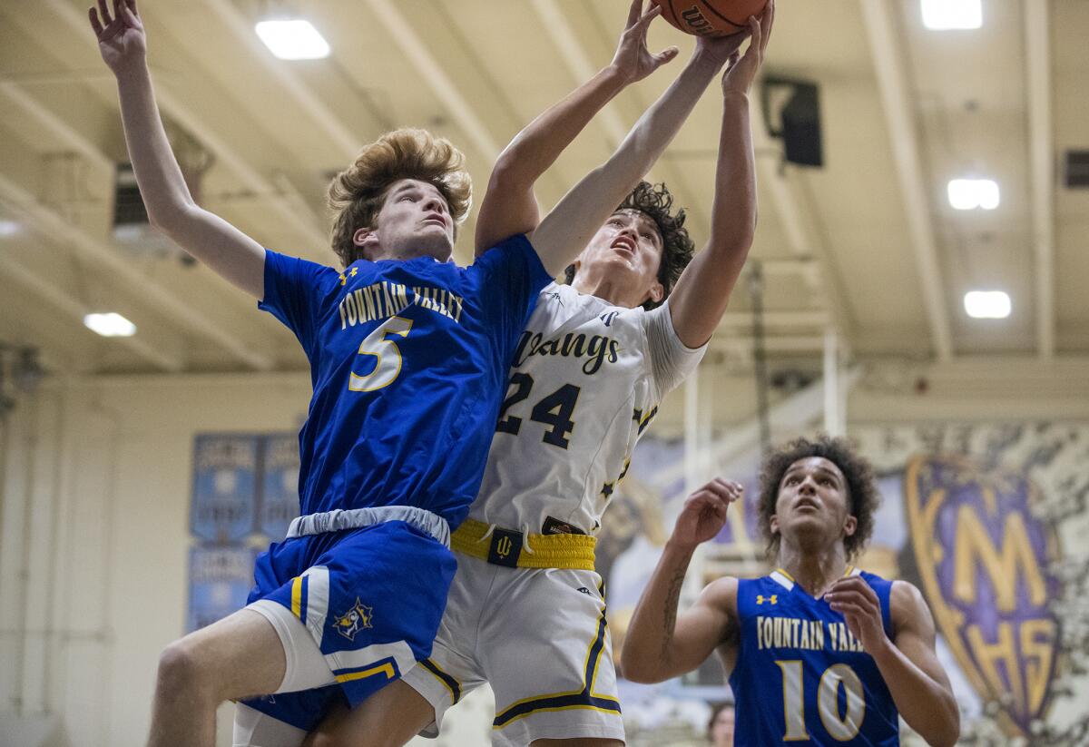 Fountain Valley's Zach Stead and Marina's Bohdi Armstrong go up for a rebound during a Wave League boys' basketball game.