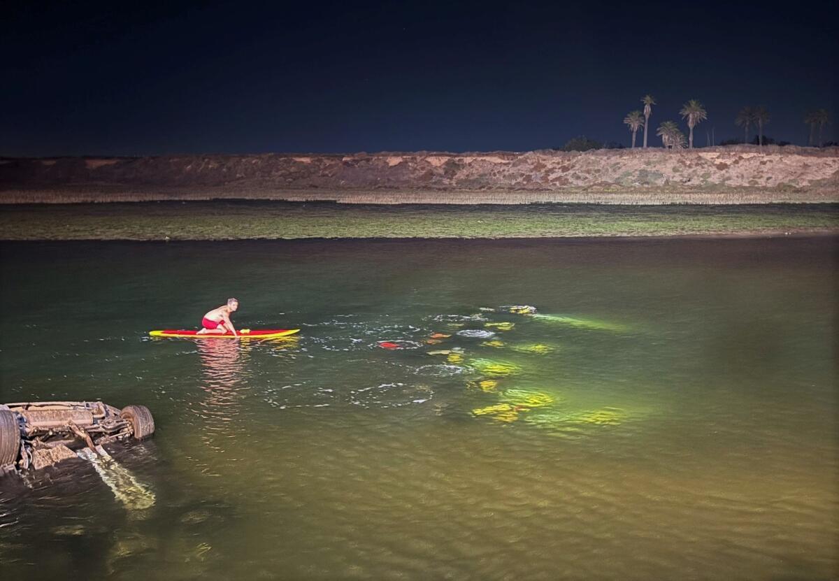 Lifeguards respond to a Nov. 20 crash involving a single vehicle submerged in the waters off PCH in Huntington Beach. 