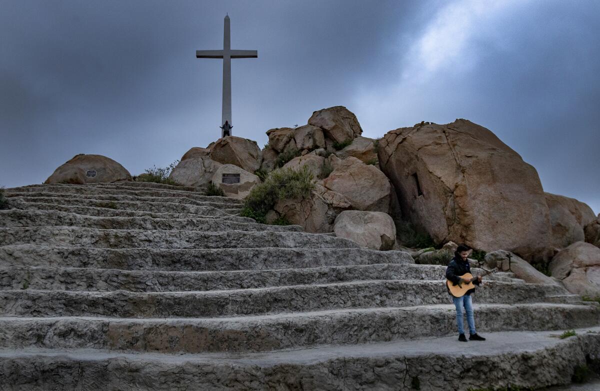 Storm clouds move in as guitarist Javon Jones of the Antioch Church sings gospel hymns during a live-streamed sunrise Easter service on Mt. Rubidoux during the coronavirus pandemic.