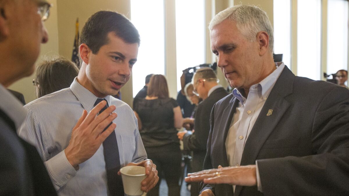 Then-Indiana Gov. Mike Pence talks with South Bend Mayor Pete Buttigieg in 2015.