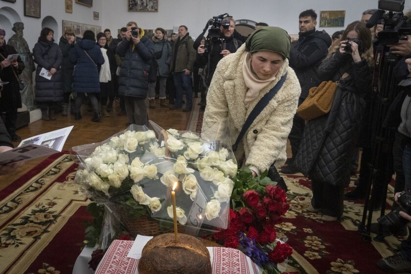 Personas colocan flores en memoria de Chris Parry y Andrew Bagshaw, voluntaries británicos Muertos en Ucrania, en la Catedral Santa Sofía de Kiev, Ucrania, el 29 de enero de 2023. (AP foto/Efrem Lukatsky)
