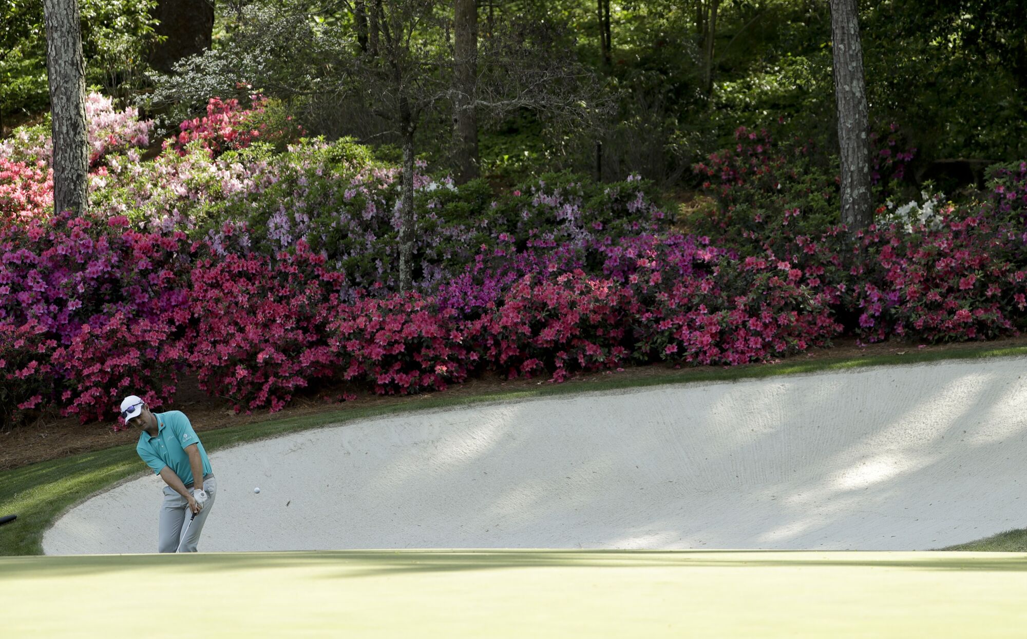 Justin Rose hits a chip on the 13th hole during practice for the 2018 Masters at Augusta National.