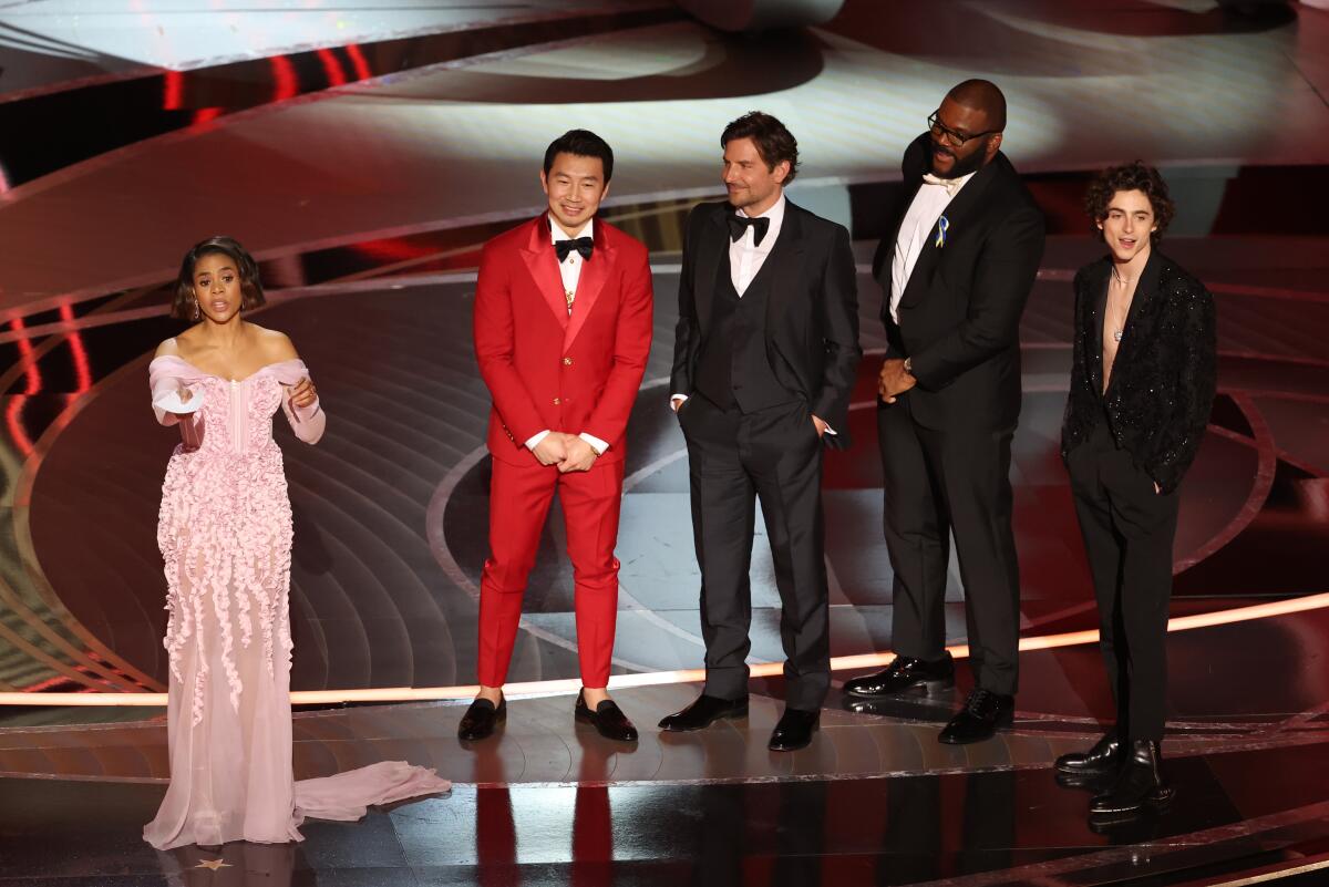 a woman in a gown and four men in tuxedos