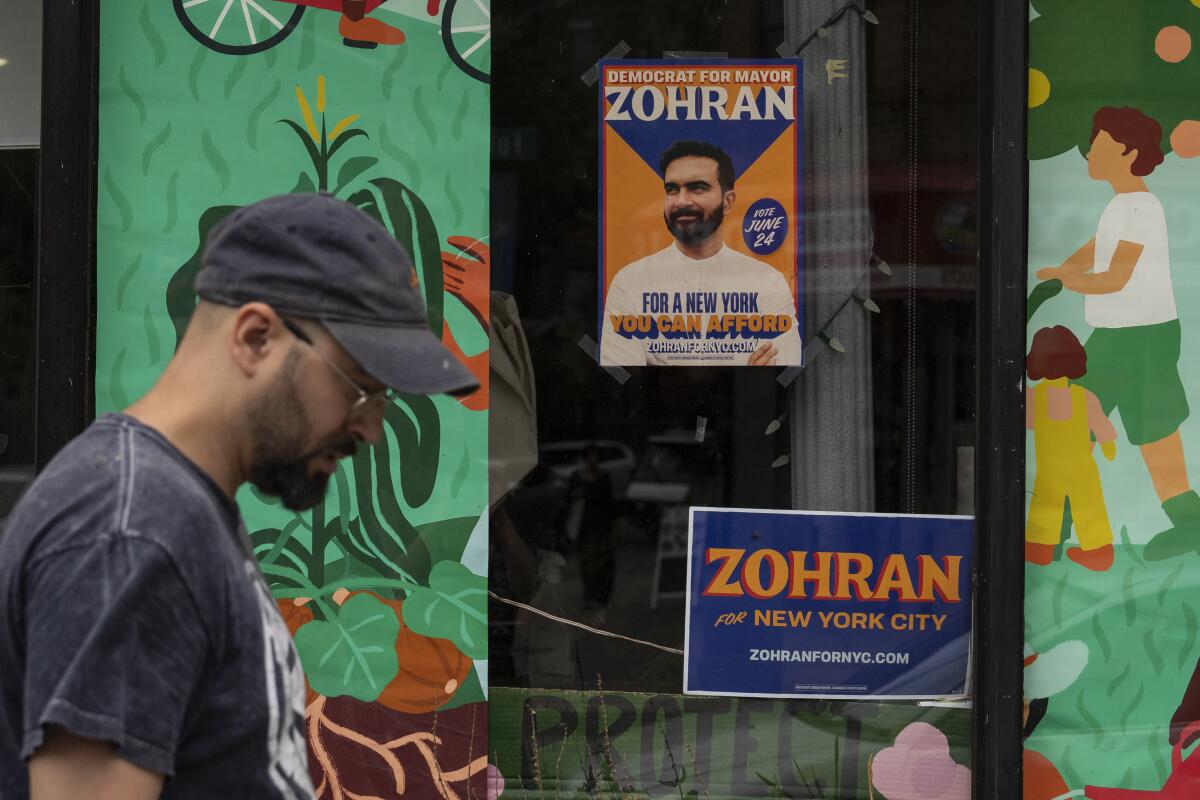 A campaign poster for Democratic mayoral candidate Zohran Mamdani is seen outside a store